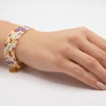 دستبند میوکی طرح گل بنفش و نارنجی روی مچ دست