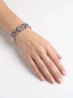 دستبند میوکی طرح پوست مار بسته شده روی مچ دست با زنجیر طلایی