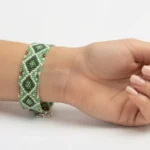 دستبند میوکی سبز با طرح لوزی بسته شده روی مچ دست