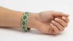 دستبند میوکی سبز با طرح لوزی بسته شده روی مچ دست