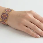 دستبند پهن میوکی با طرح هندسی بنفش، مسی و طلایی، بسته شده روی مچ دست